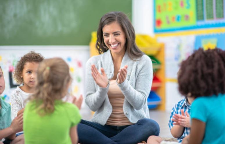 Teacher with students clapping hands