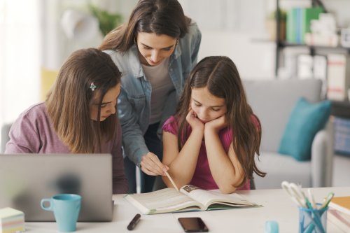 a woman teaching two kids